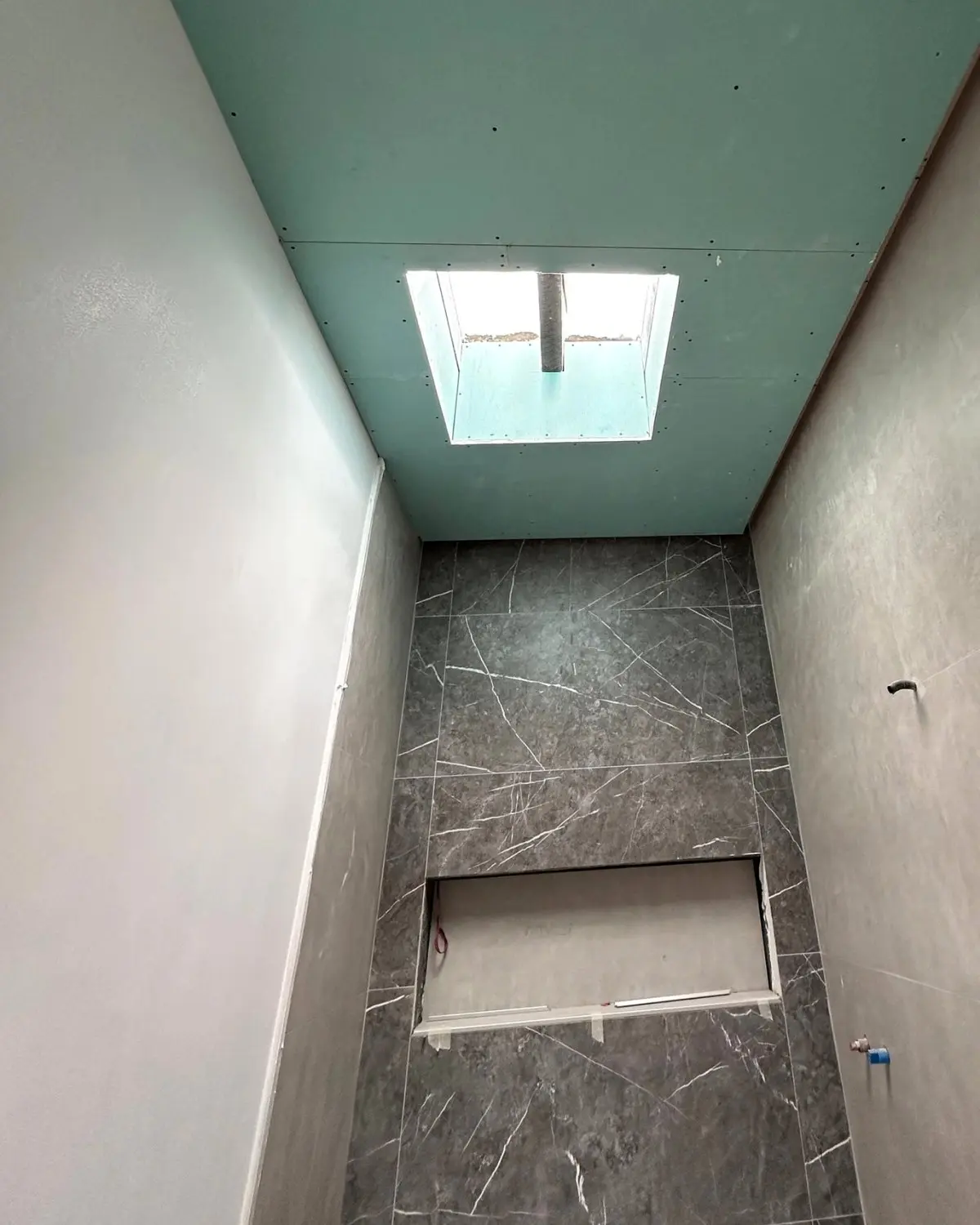 El mismo baño con el techo de placa hidrófuga cerrado alrededor del lucernario