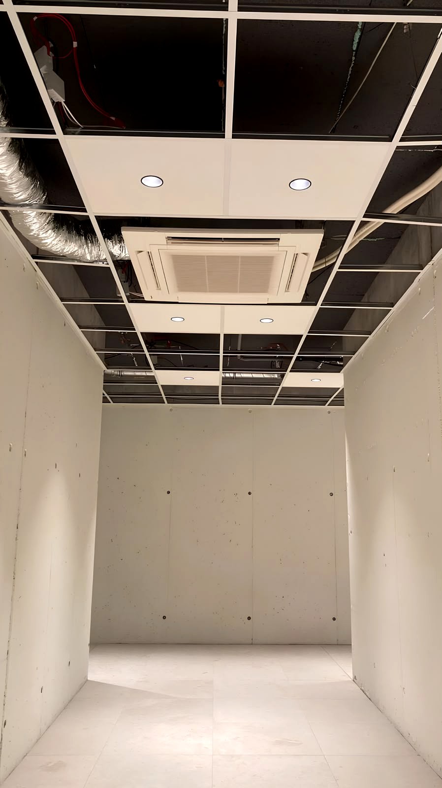 Proceso · Techo registrable con placas colocadas parcialmente y ducting de climatización integrado, fase de cierre