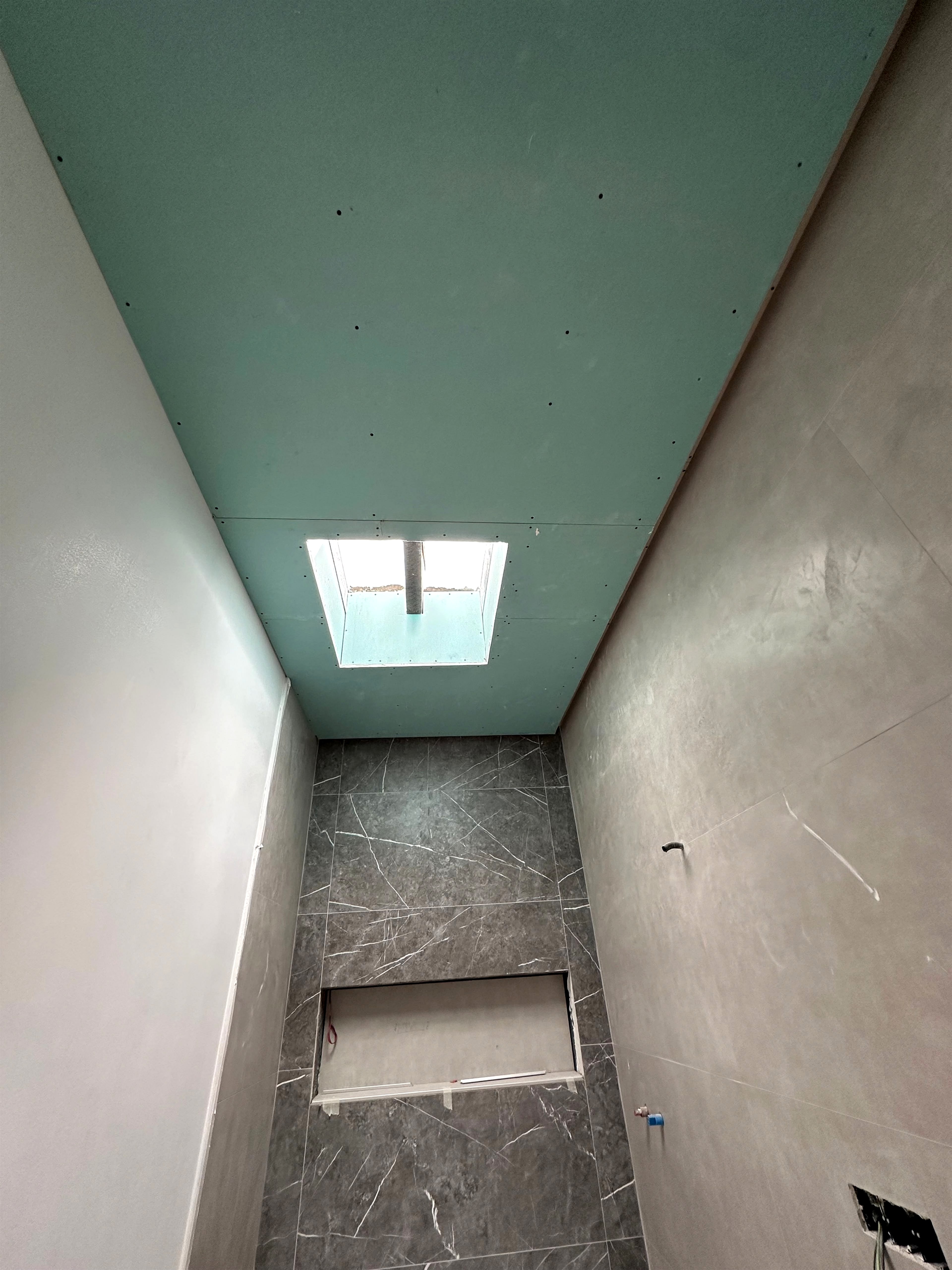 Baño terminado con techo continuo PYL hidrófugo, tragaluz integrado y trasdosado